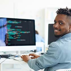 Computer Science graduate sitting at a computer