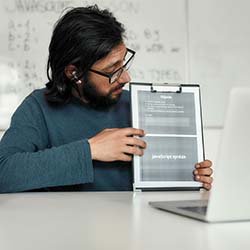 Teacher holding tablet showing JavaScript syntax