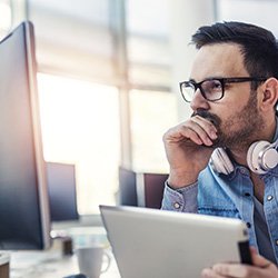 software developer looking at a screen and thinking